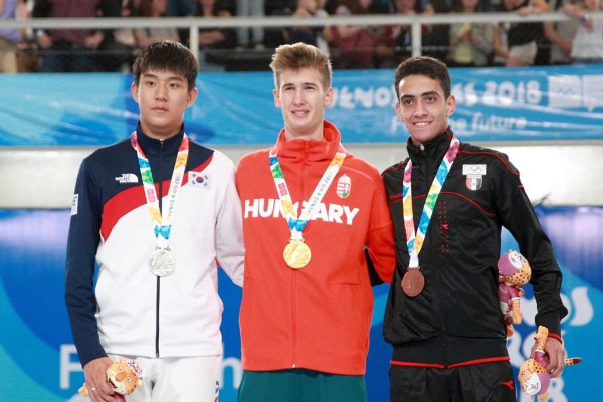 three athletes wearing silver, gold and bronze medals